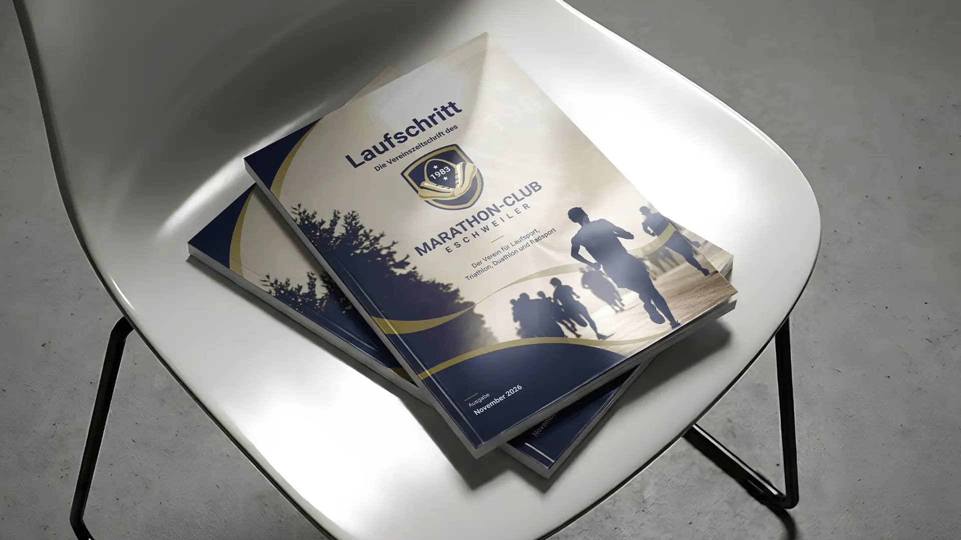 Vereinshefte des Marathon-Club Eschweiler, die auf einem weißen Stuhl liegen